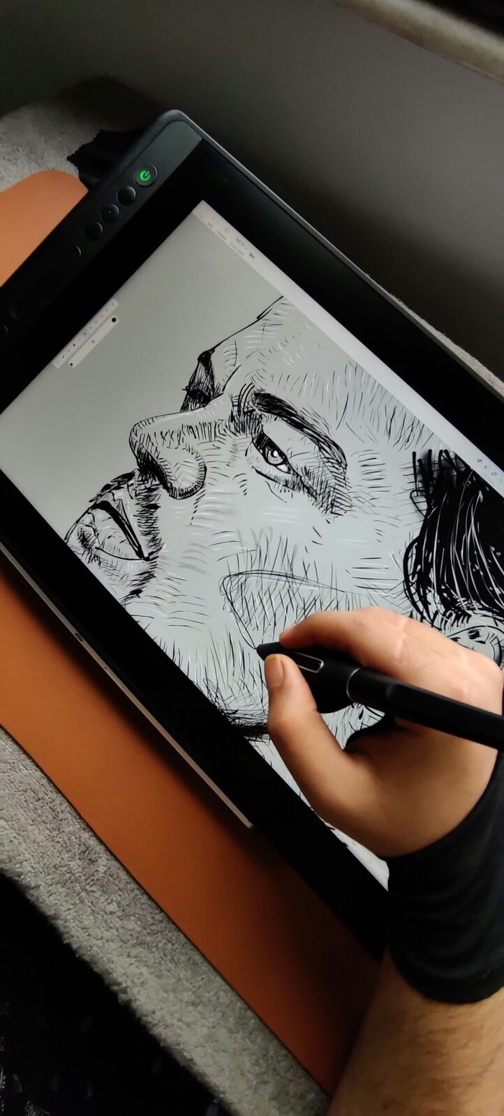 Hand drawing a detailed ink portrait on a pen display